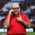 Gustavo Guzmán Sepúlveda hablando por teléfono camiseta roja Atlas